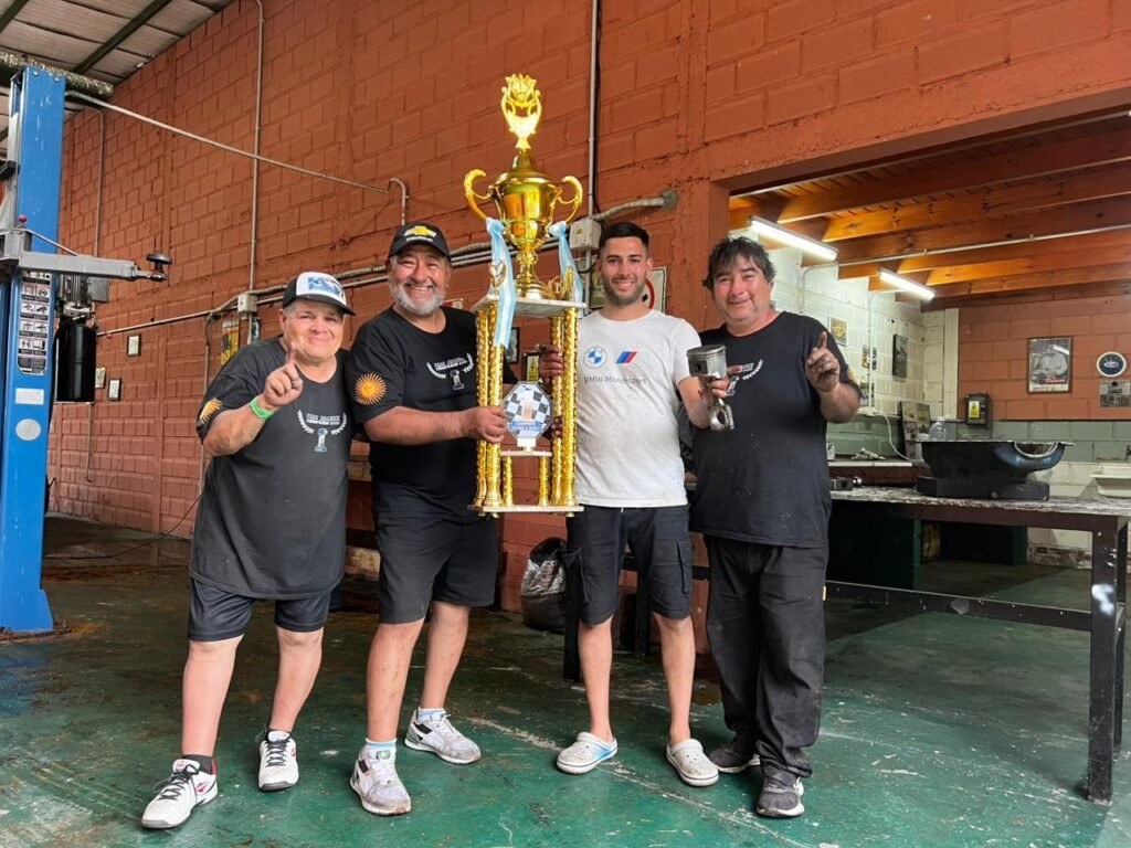 Federico Juárez con su grupo y el trofeo de campeón